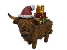 Beeld Hooglander koe figuur kerstdecoratie Polystone kerstmuts cadeautjes met LED 22x11x22cm bruin